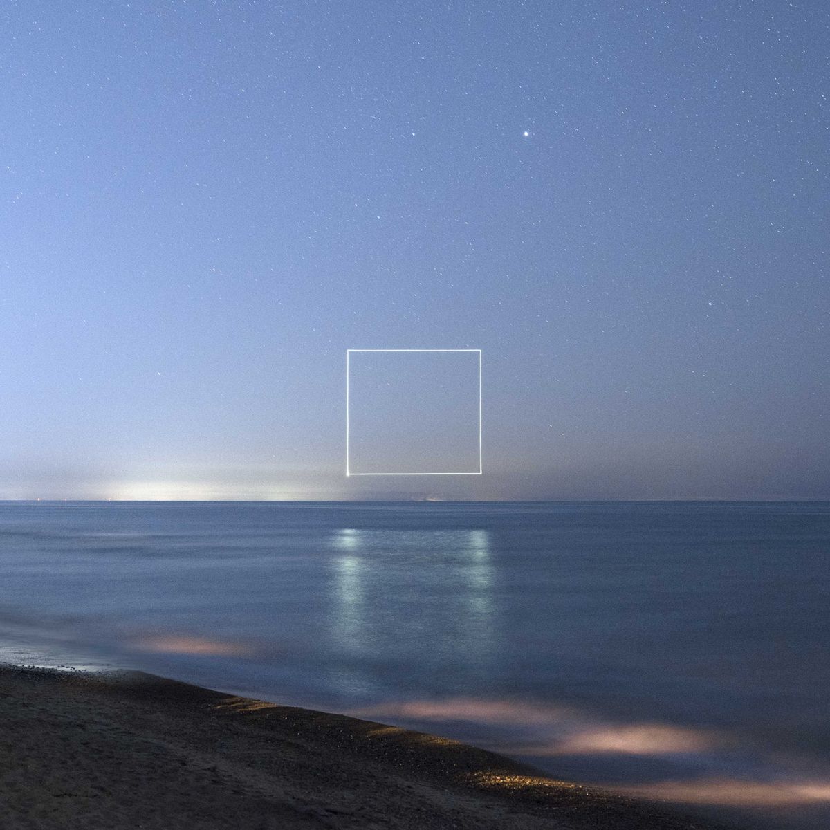 Long exposure photo of the ocean with a square of light traced by a drone