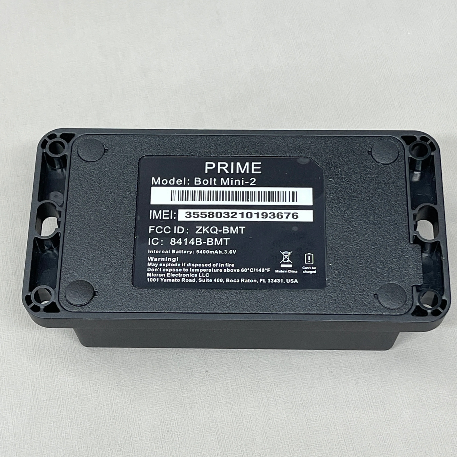 Photo of the back of a GPS tracker, with model name and IMEI number
